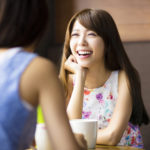 two young woman chatting in a coffee shop